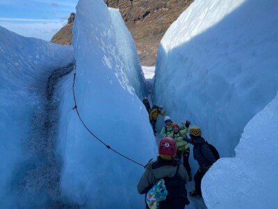 group walking through a narrow ice passage