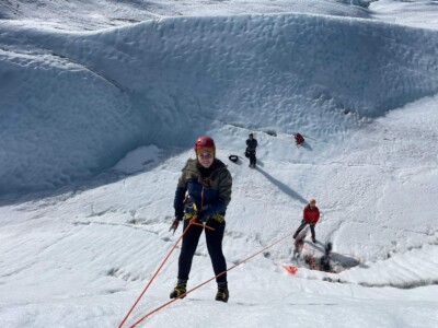 man being lowered from ice wall