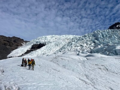 group hiking with icefall background